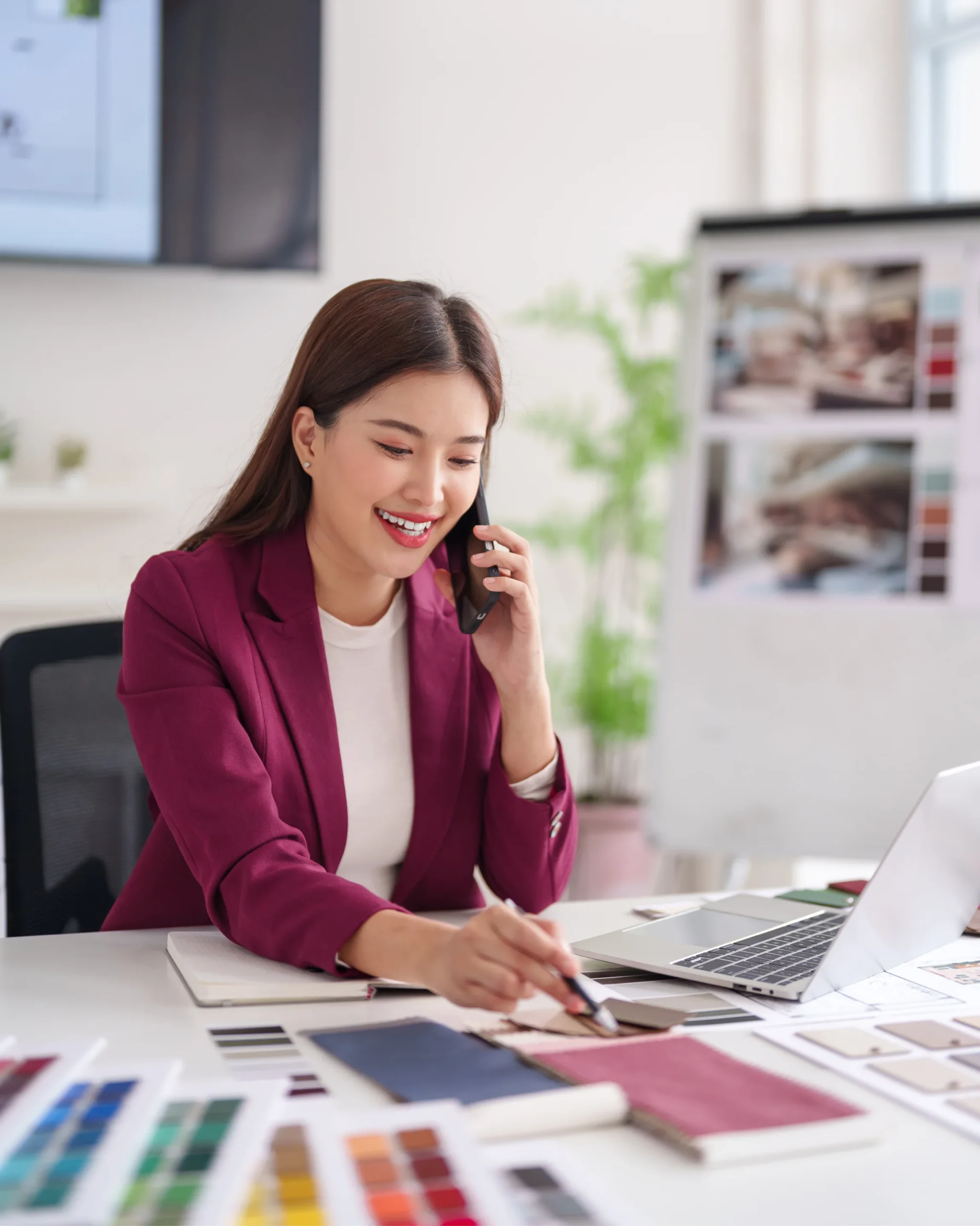 A smiling web design professional on a call while reviewing a project on a laptop, representing KMP Digital Media's professional web design and development services
