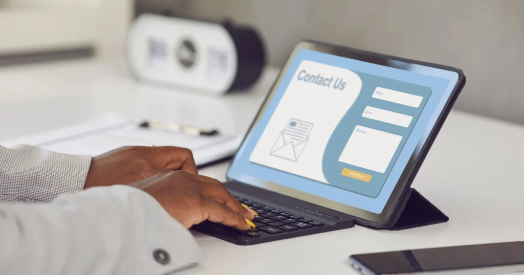 Person submitting a contact form on a laptop, illustrating website conversion for small business leads